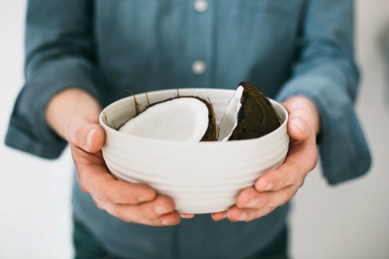 man holding coconut in a bowl